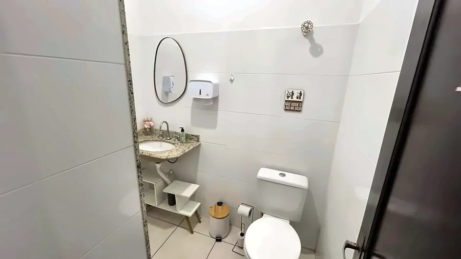 Banheiro com pia de granito e espelho.
