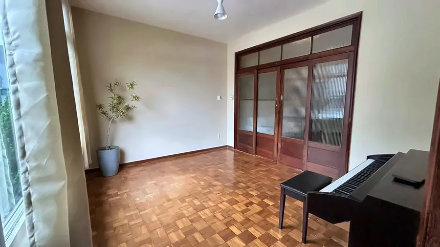 Outro ângulo da sala coletiva, com as portas de madeira.