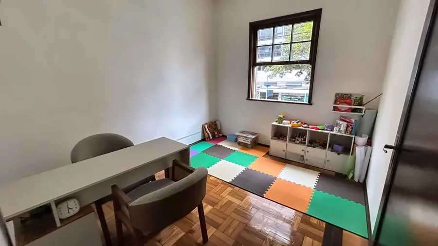 Outro ângulo da sala infantil, com a mesa e as cadeiras.