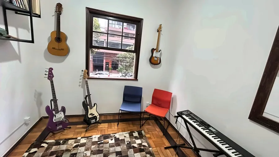 Sala de música vista de frente, com a janela e os instrumentos.
