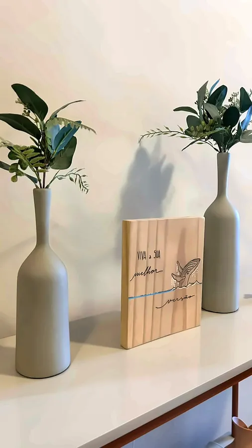 Detalhe da recepção: vasos com folhagens e uma placa de madeira.