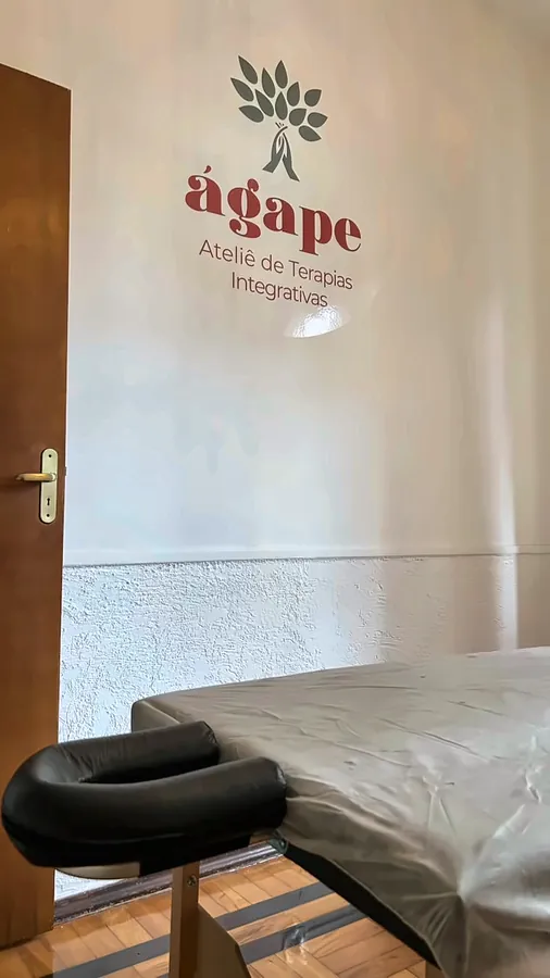 A marca do Ágape na parede, ao lado da maca.
